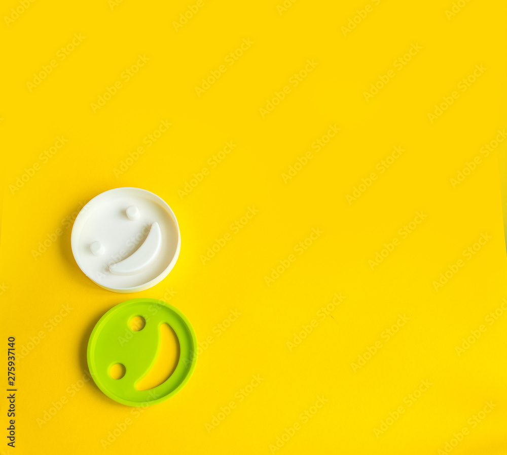 Smiley in woman's hands on yellow background with copy space. Happy work day concept Smiley in woman's hands on yellow background with copy space. Happy work day concept