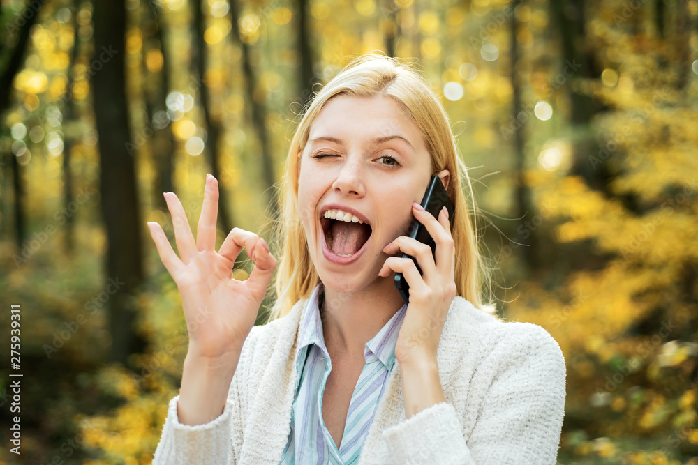 Happy young woman preparing for autumn sunny day. Happy girl posing with phone. Social media phone. Phone happy outdoor. Smartphone girl on autumn nature background. Happy young woman preparing for autumn sunny day. Happy girl posing with phone. Social media phone. Phone happy outdoor. Smartphone girl on autumn nature background.