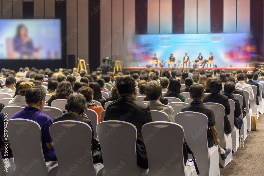 Rear view of Audience listening Speakers on the stage in the conference hall or seminar meeting, business and education about investment concept