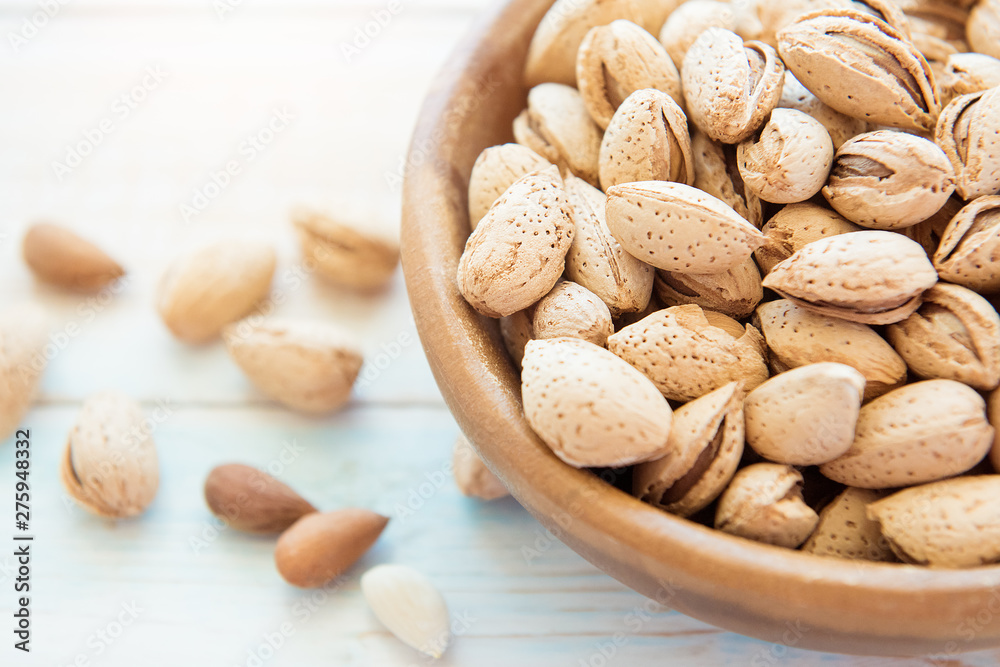 Wooden bowl with shelled almonds on a light table Wooden bowl with shelled almonds on a light table