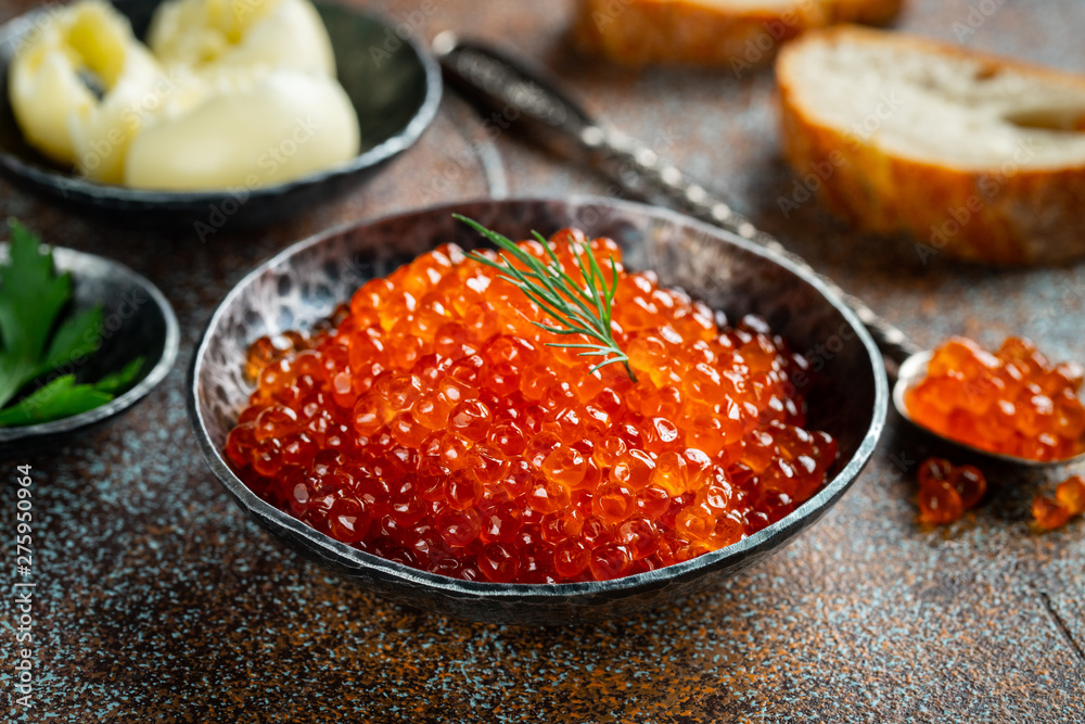 Delicious red caviar in black bowl on a dark concrete background Delicious red caviar in black bowl on a dark concrete background