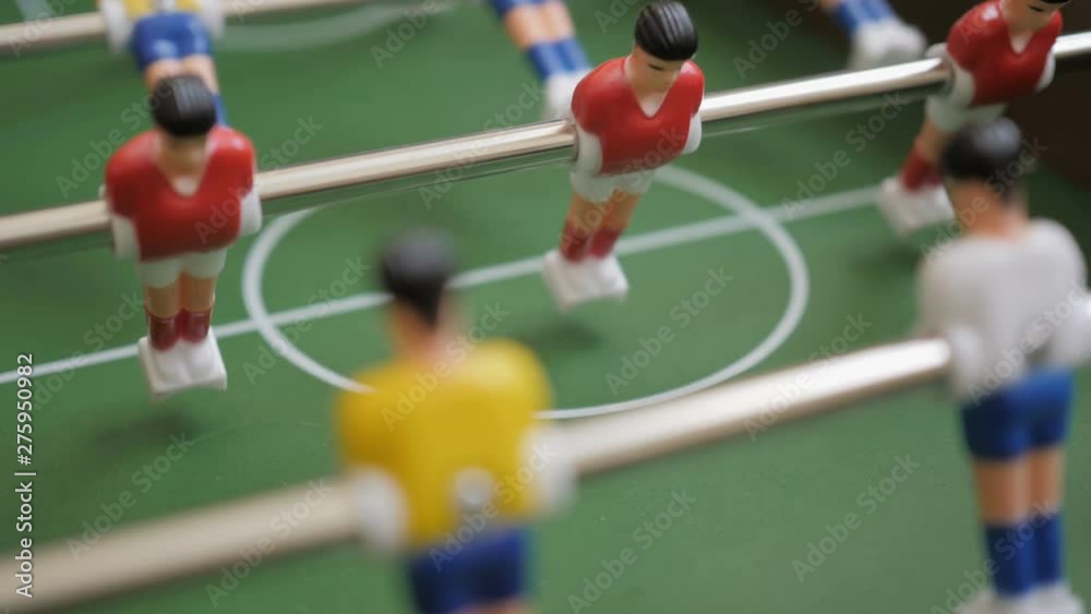 Friends Playing Table Soccer Game Closeup. People playing in table football or kicker with miniature players. Slow Motion. Shallow DOF. Playing Football Soccer on game table. Close Up. Friends Playing Table Soccer Game Closeup. People playing in table football or kicker with miniature players. Slow Motion. Shallow DOF. Playing Football Soccer on game table. Close Up.