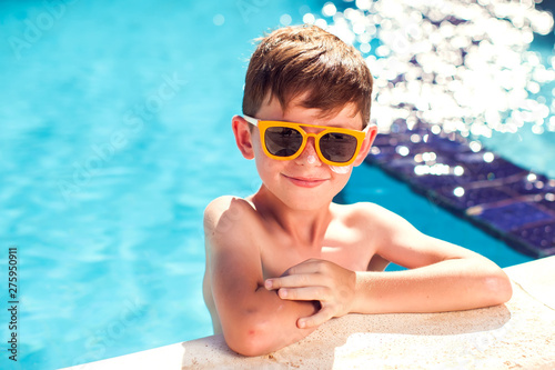 Kid boy with sun protection cream on his skin in the pool. Children, summer, holiday and healthcare concept © Aleksej