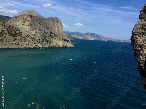 Blue Cove with a populated tourist city. Crimean sea and mountains, summer holiday tourists.