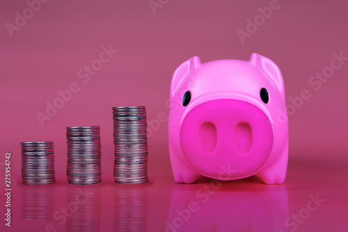 Pink piggy bank save coin on pink background, Piggy pink bank with growth coins which means grwoth business success concept. photo