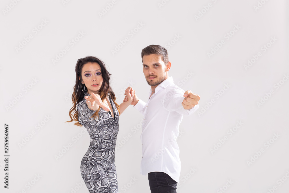 Social dance, bachata, kizomba, tango, salsa, people concept - Young couple dancing over white background with copy space Social dance, bachata, kizomba, tango, salsa, people concept - Young couple dancing over white background with copy space