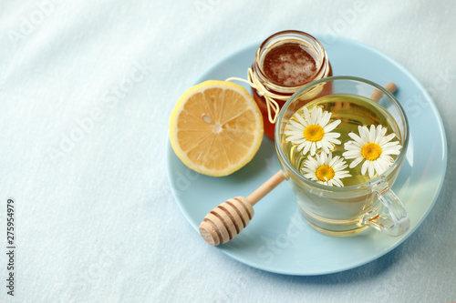 Chamomile flowers and chamomile tea. Chamomile tea in glass teacup with flowers, honey and lemon, top view, prevention of seasona flu colds