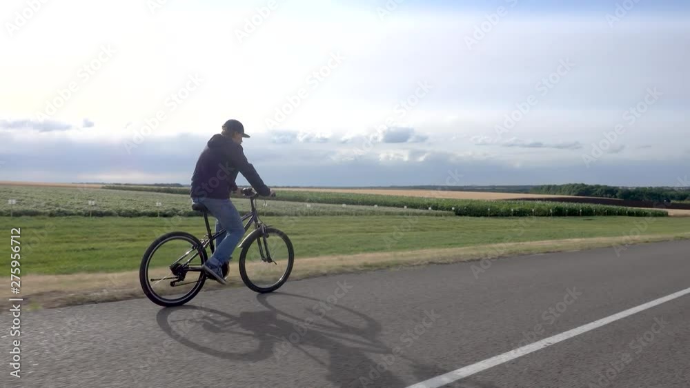 Teen boy on bike cycling Front full length view of during sunset. Teen boy on bike cycling Front full length view of during sunset.