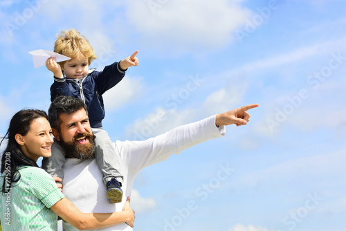 Happy family - mother, father and son on sky background in summer. Happy father giving son back ride on sky in summer. Family Time. Dream of flying.