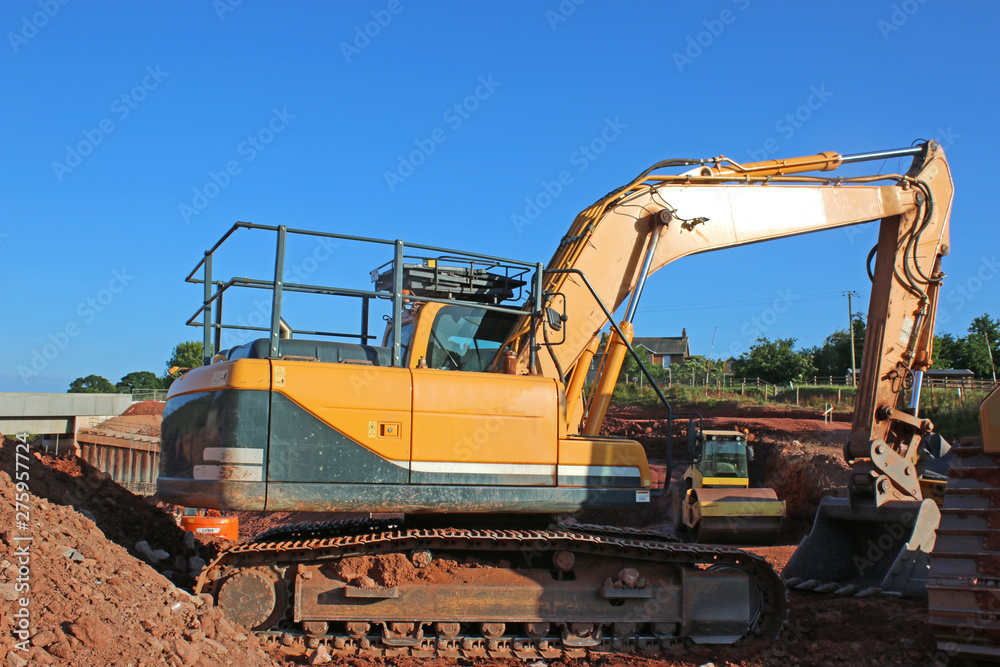 Digger working on a road construction site Digger working on a road construction site