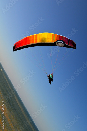 paraglider flight through the blue sky photo