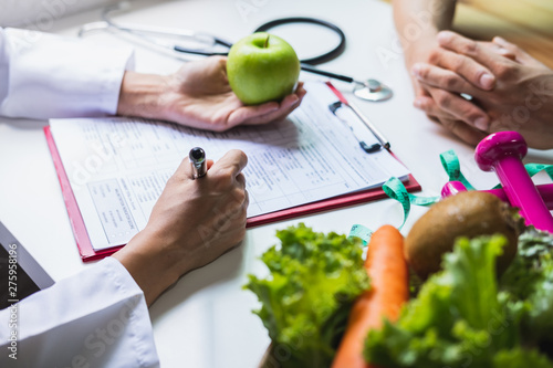 Fototapeta Dietetyk udzielający konsultacji pacjentowi ze zdrowymi owocami i warzywami, właściwego odżywiania i diety