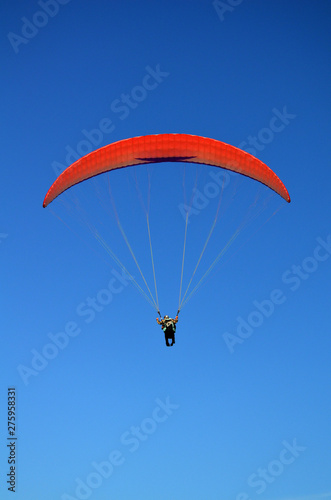 paraglider flying on the blue sky