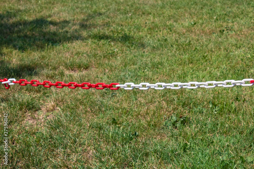 Red and white plastic chain prohibiting parking closeup - Image
