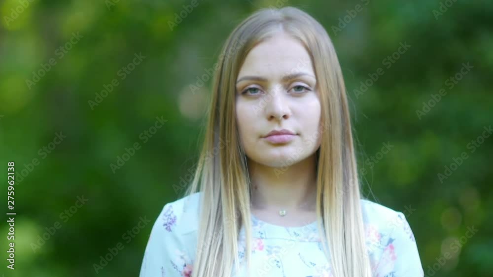 portrait of a beautiful woman standing on a natural green background in a summer park portrait of a beautiful woman standing on a natural green background in a summer park