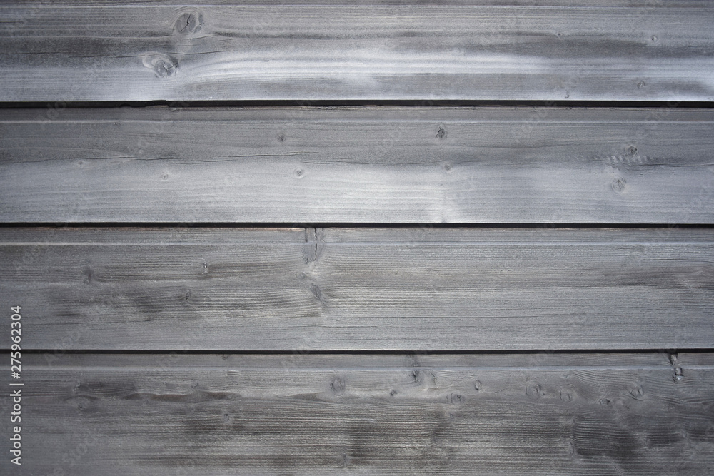 Naklejka premium Old wooden surface of tightly nailed planks with cracks and knots. Grey background close-up. Selective focus. Copy space.