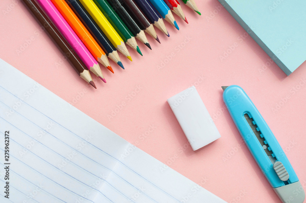 Notebook and colored pencils on a pink background Notebook and colored pencils on a pink background