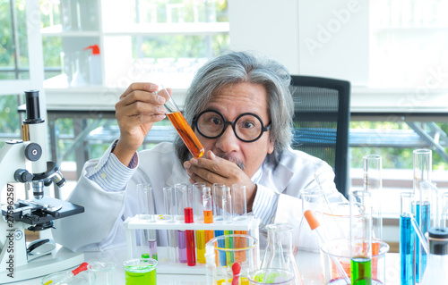 Senior male supervisor doing experiments and researchers working in the laboratory.