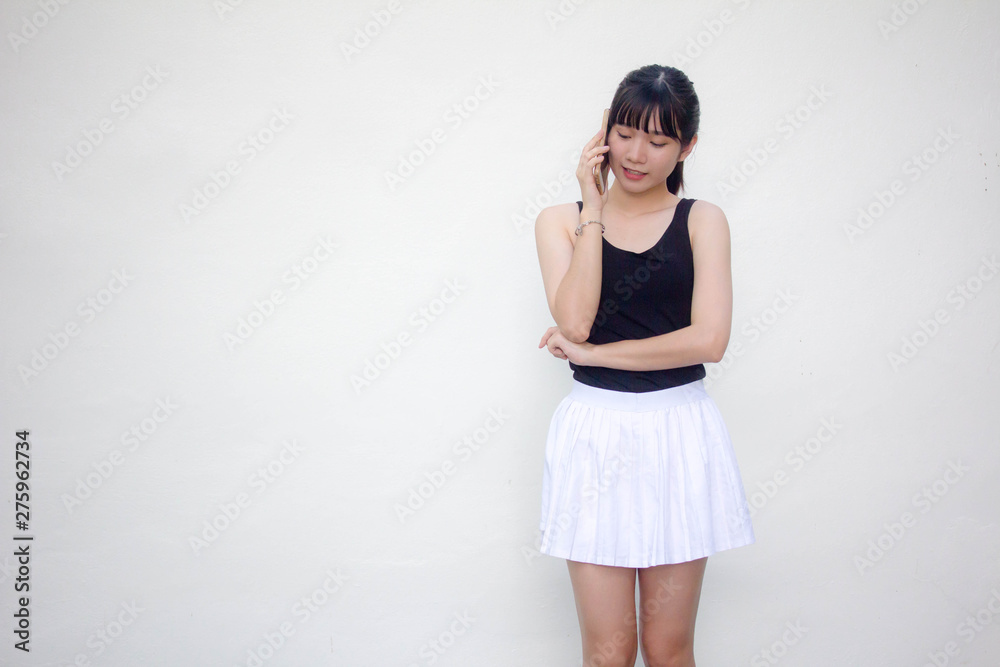 Portrait of thai adult beautiful girl black shirt white skirt calling smart phone Portrait of thai adult beautiful girl black shirt white skirt calling smart phone