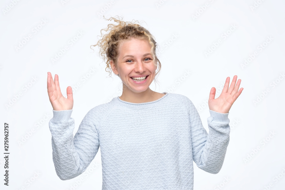 Beautiful amazing pretty young curly woman with arms raised can not believe her showing large size with hands. Positive facial human natural emotion Beautiful amazing pretty young curly woman with arms raised can not believe her showing large size with hands. Positive facial human natural emotion