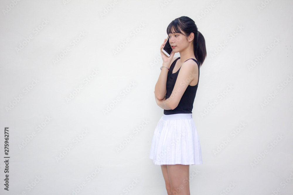 Portrait of thai adult beautiful girl black shirt white skirt calling smart phone Portrait of thai adult beautiful girl black shirt white skirt calling smart phone