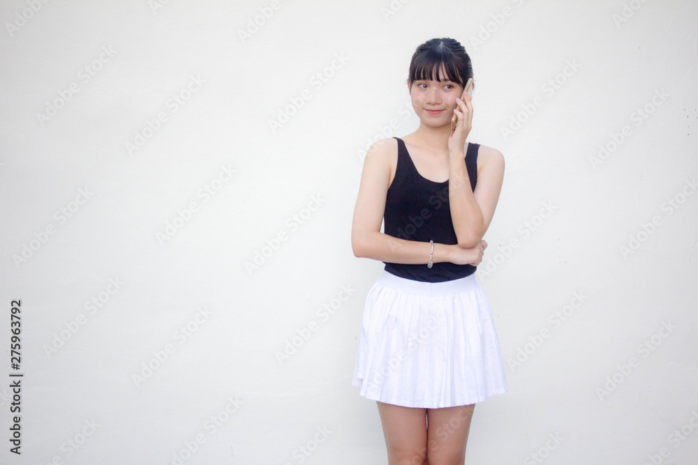 Portrait of thai adult beautiful girl black shirt white skirt calling smart phone Portrait of thai adult beautiful girl black shirt white skirt calling smart phone