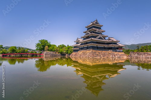 Matsumoto - May 25, 2019: The castle of Matsumoto and the red bridge leading to it, Japan © rpbmedia