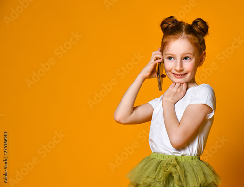 Portrait of the little girl positive that talking on cell phones