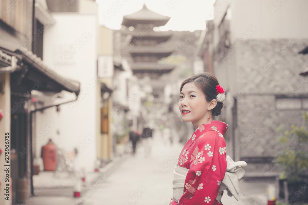 Asian woman wearing traditional Japanese kimono walking in the old town of Kyoto, Japan