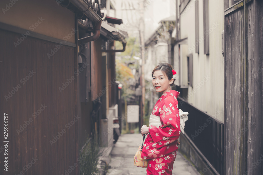 Asian woman wearing traditional Japanese kimono walking in the old town of Kyoto, Japan Asian woman wearing traditional Japanese kimono walking in the old town of Kyoto, Japan