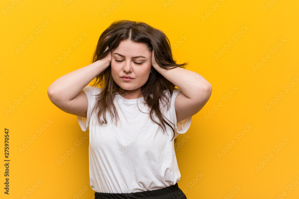Young curvy plus size woman touching temples and having headache. Young curvy plus size woman touching temples and having headache.