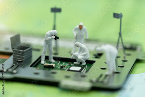 Fotografie Miniature people searching for bugs on microchip