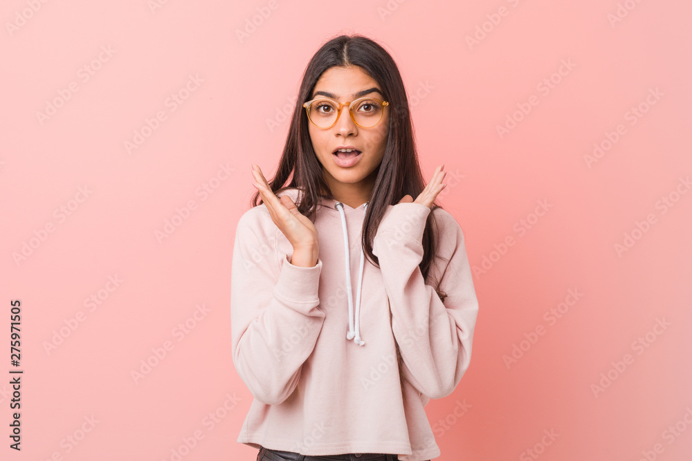 Young pretty arab woman wearing a casual sport look surprised and shocked.