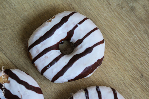 selfmade vanilla donuts on table. The donuts have white glaze with brown chocolate photo