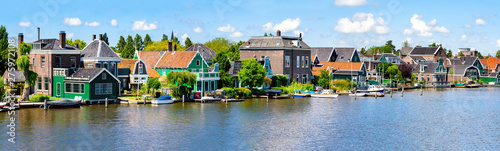 Panorama with row of old dutch green traditional houses in town Zaanse Schans/ Zaandijk in Netherlands, North Holland near Amsterdam photo
