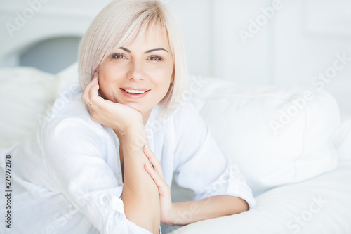 Attractive mid adult woman portrait. Female indoors closeup portrait. Blond woman at home beauty portrait.