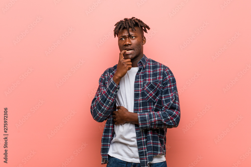 Young african black man relaxed thinking about something looking at a copy space. Young african black man relaxed thinking about something looking at a copy space.