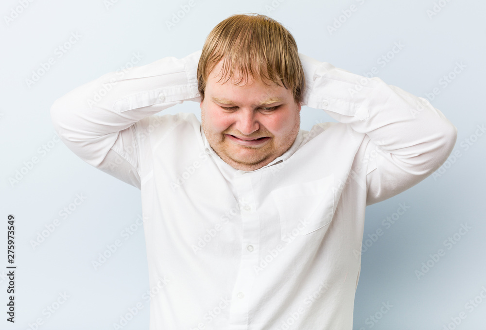 Young authentic redhead fat man covering ears with hands trying not to hear too loud sound. Young authentic redhead fat man covering ears with hands trying not to hear too loud sound.