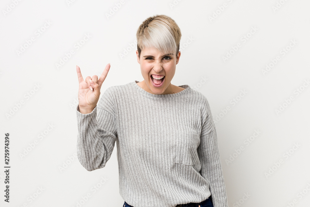 Young curvy caucasian woman isolated on white background showing a horns gesture as a revolution concept. Young curvy caucasian woman isolated on white background showing a horns gesture as a revolution concept.