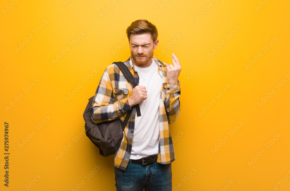 Young redhead student man crossing fingers for having luck Young redhead student man crossing fingers for having luck