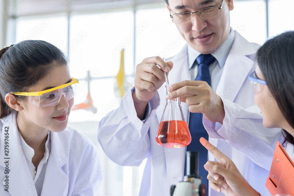 Asian yound student scientist researching and learning with senior scientist have teaching background in a laboratory. Asian yound student scientist researching and learning with senior scientist have teaching background in a laboratory.