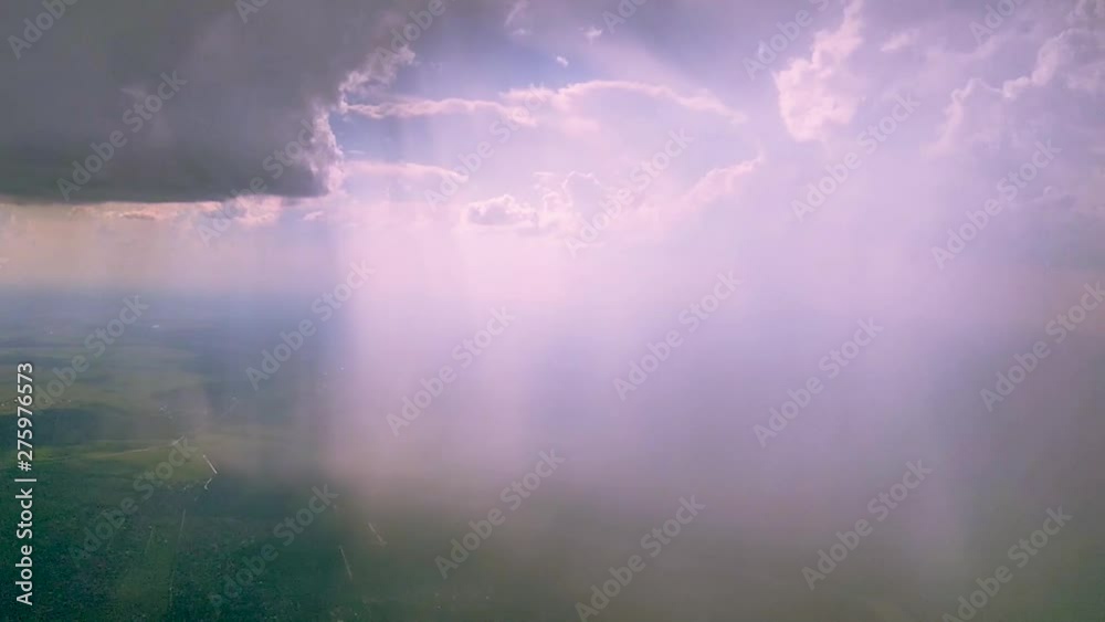 Clouds on blue sky and sun rays shot from the window of a flying airplane. Selective focus.