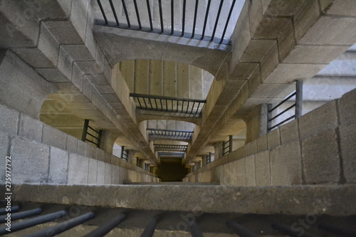 View Looking Straight Down a Stairwell Made of Ancient Granite Stone with an Cast Iron Handrail