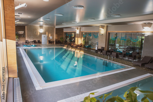 beautiful indoor pool with Jacuzzi with rattan furniture and large panoramic Windows, lighting and finished in loft style