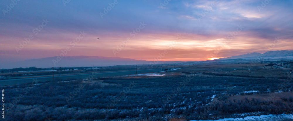 Panoramic landscape of a valley with mountains in the background at sunset