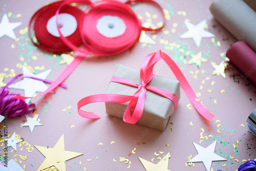 A gift with a pink flight on a festive background with stars. A gift with a pink flight on a festive background with stars.