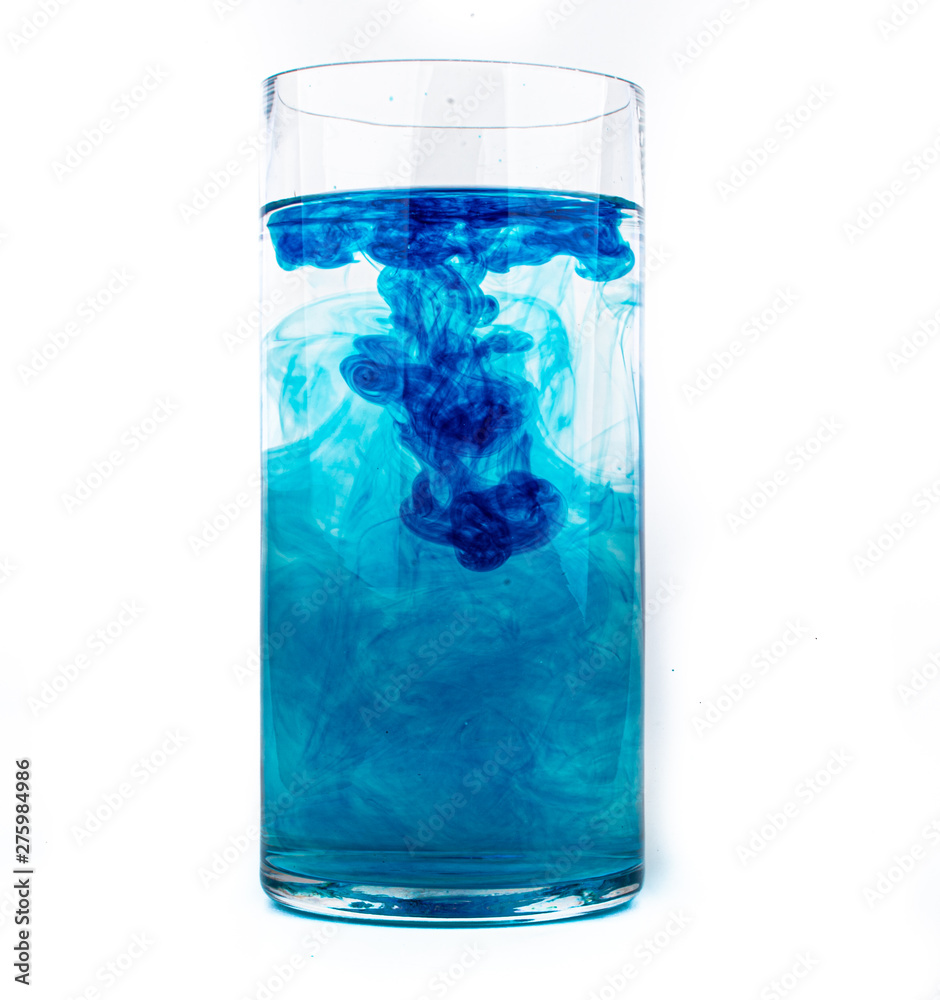 Blue food coloring diffuse in water inside glass with empty copyspace area for slogan or advertising text message, over isolated white background. Blue food coloring diffuse in water inside glass with empty copyspace area for slogan or advertising text message, over isolated white background.