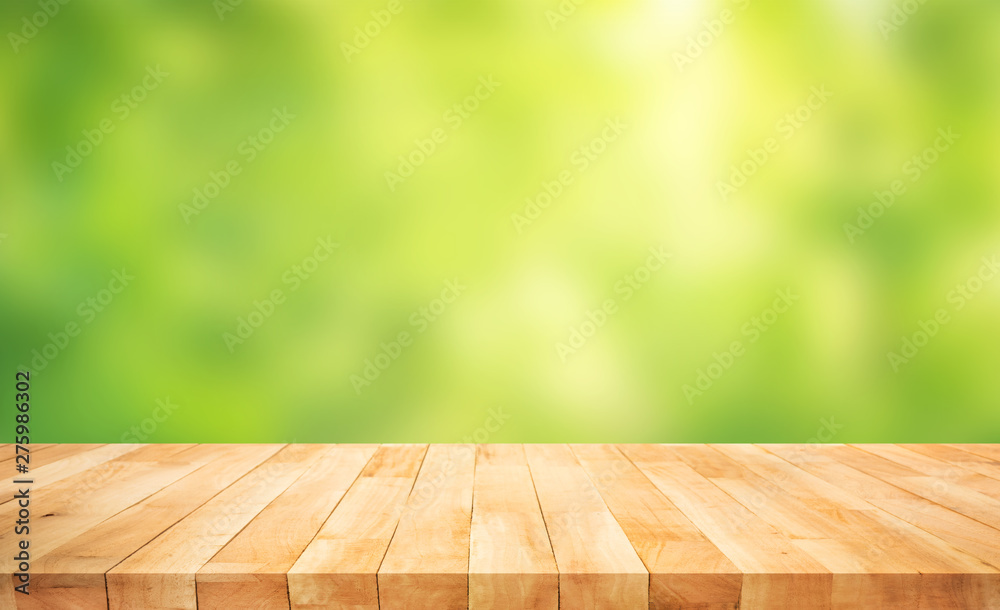Real wood table top texture on blur fresh green garden background