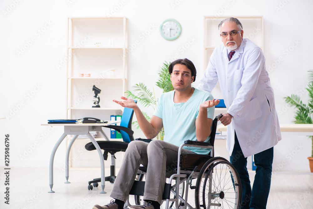 Male patient in wheel-chair visiting old doctor Male patient in wheel-chair visiting old doctor