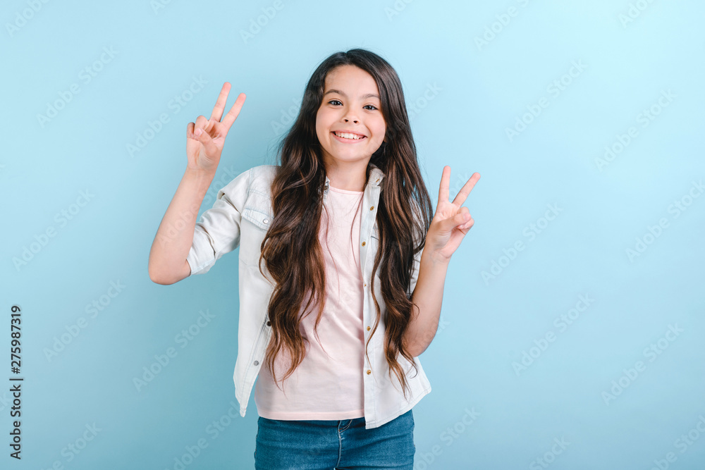 Young pretty girl smiling and showing a victory gesture looking at the camera . - Image Young pretty girl smiling and showing a victory gesture looking at the camera . - Image